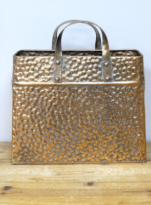A very attractive planter in the style of a bag, but instead of fabric it is made from hammered metal in a copper type of finish.
Suitable for artificial plants or flowers only. 
Front view shown on shelf
Height 36 cm and width 33 cm.