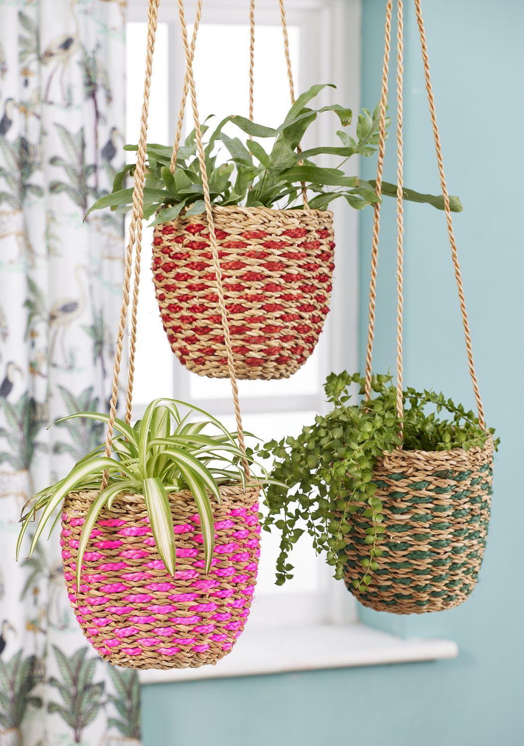 These hanging baskets are made from natural Hogla Grass and this set of three are finished in three different shades to add colour to your room.