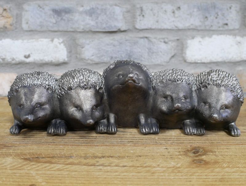 Row of five hedgehog-shaped metal planters with a weathered grey finish