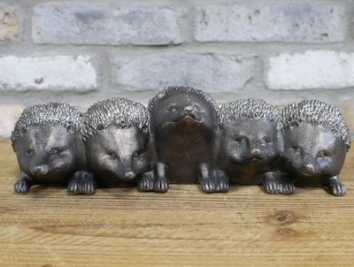 Row of five hedgehog-shaped metal planters with a weathered grey finish