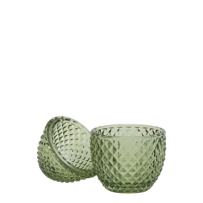 Small decorative green glass container with a diamond-cut texture and a rounded lid, shaped like an egg. Shown open in half.