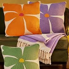 Sunshine Cushions with bold flower designs in orange, purple and green.