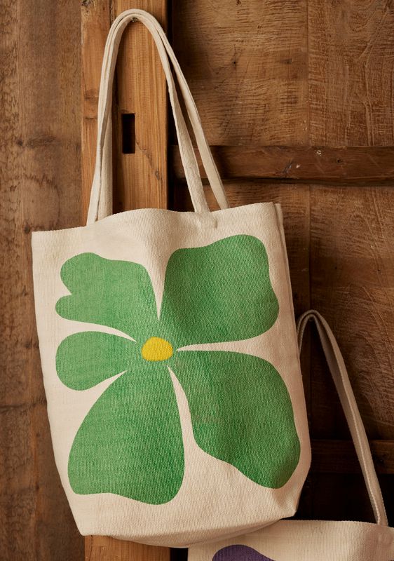 Canvas tote bags with bold flower prints in green, purple, red, orange and pink.