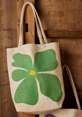 Canvas tote bags with bold flower prints in green, purple, red, orange and pink.