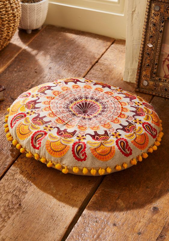 Round embroidered mandala cushions with elephant and floral patterns, finished with small pom pom edging