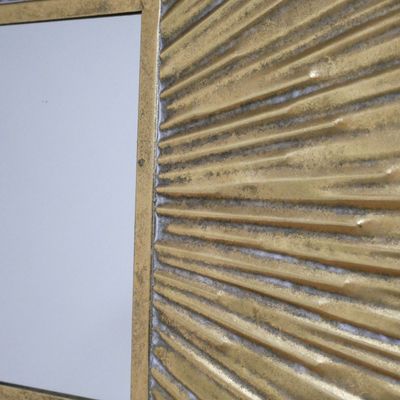 Decorative square wall mirror with a metallic gold frame featuring raised, radiating ridges forming a sunburst pattern