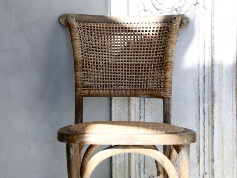 A close up view of the french wicker chair that we supply as a pair, showing the rattan work on the chair backrest.