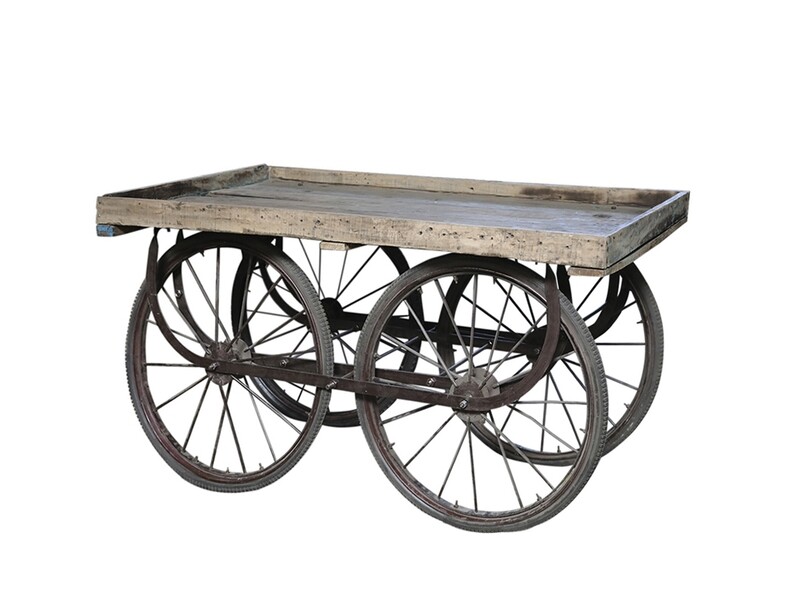 Vintage French cart with weathered wooden top and metal frame, featuring four iron-spoked wheels.