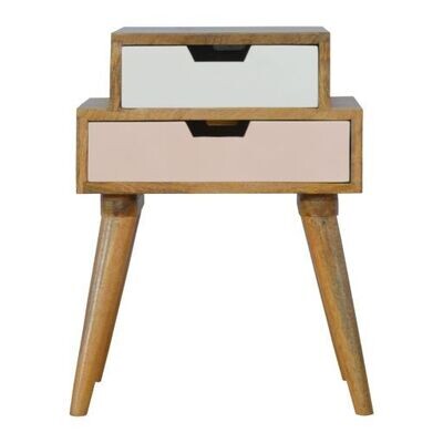 Blush pink and white stacked bedside cabinet with two offset drawers, natural wood frame, and tapered wooden legs on a white 