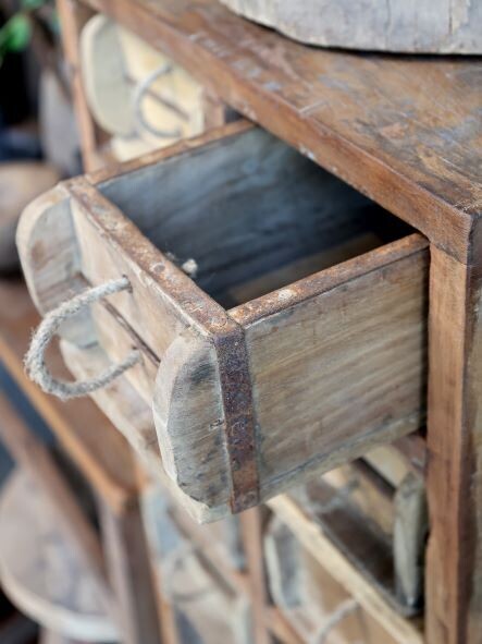 Tall wooden storage cabinet with 20 small drawers, each fitted with a metal cup handle for vintage workshop style.