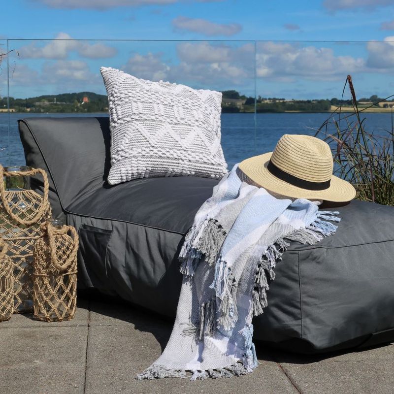 Soft Cushion Bed finished in coal dressed with cushion, throw and hat outside