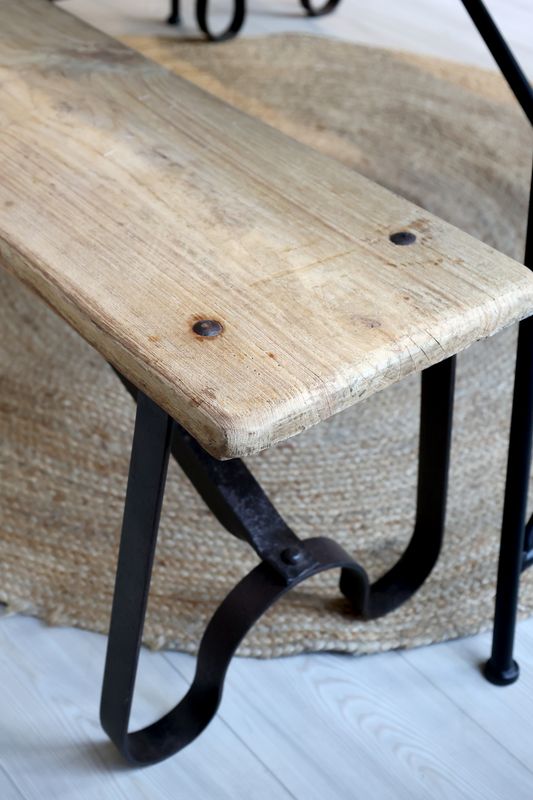 The end view of the Grimaud bench showing the legs of the black iron frame