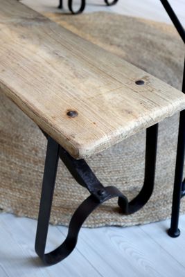 The end view of the Grimaud bench showing the legs of the black iron frame