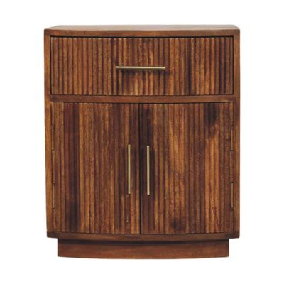 Wooden bedside cabinet with one top drawer, two-door cupboard, fluted front panels, and brushed metal handles.