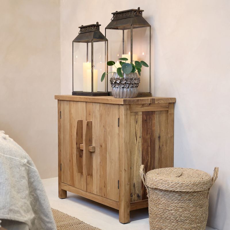 A compact wooden cabinet made from natural light-toned wood with visible grain. It has a rectangular top, two front doors.