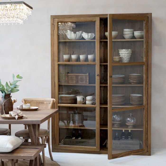 Tall wooden display cabinet with glass doors and internal shelving, designed to showcase decorative items.