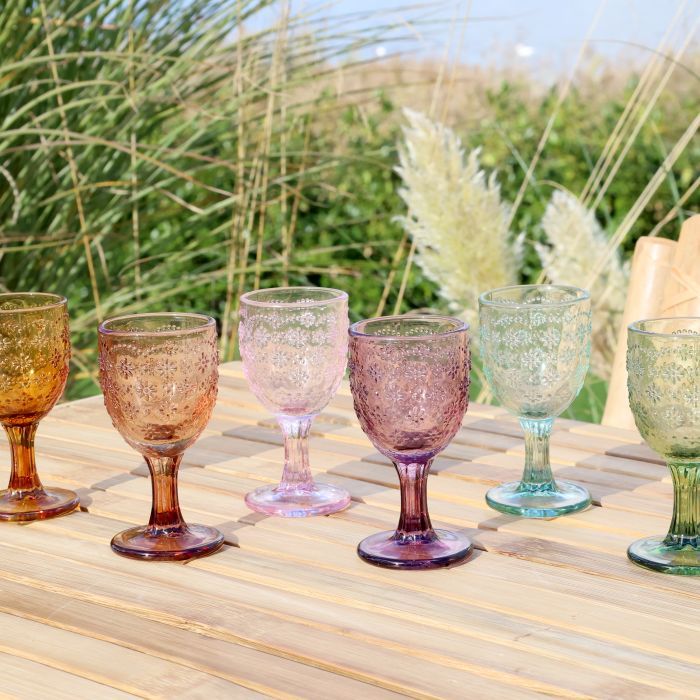 Set of six Spangles Confetti wine glasses in assorted colours, set on a wooden table