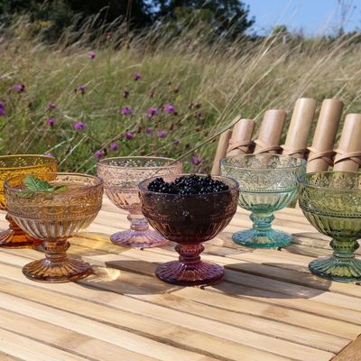 Set of six Spangles Confetti sundae glasses in assorted colours, each a different colour, arranged on a wooden outdoor table.