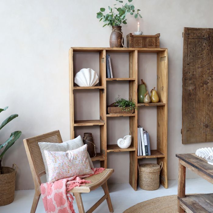 Tall wooden open shelving unit with multiple staggered compartments, shown against a black background.  Dressed