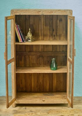 Wooden display cabinet with double glass doors and internal shelves, finished in a natural, lightly weathered wood tone.