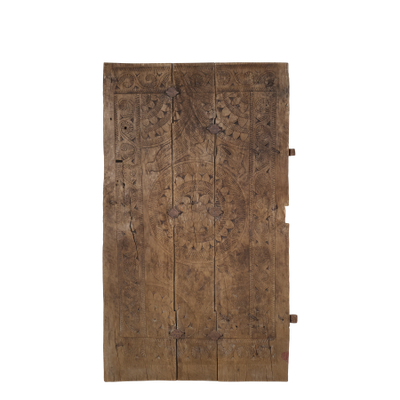 Antique Indian village door with intricate hand-carved patterns, weathered wood and aged patina.
