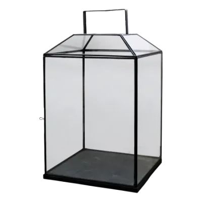 Clear glass lantern with black metal frame and handle, designed to hold a candle and add soft ambient light.