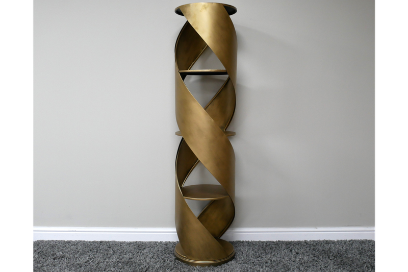 Tall gold-toned display cabinet with a twisting sculptural frame and open shelves for storing and showcasing decorative objec