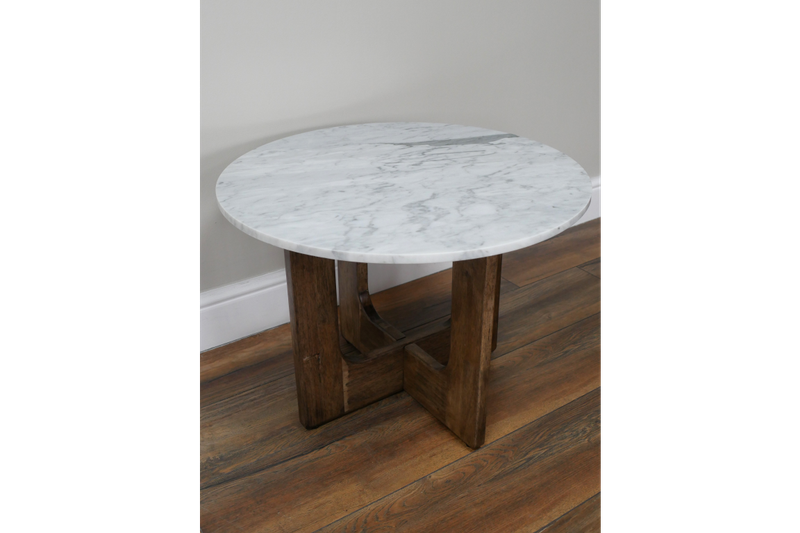 Round marble top side table with a warm wooden base, featuring curved cut-out legs and a simple, balanced design