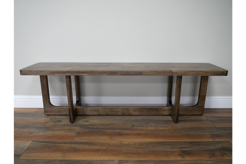 Wooden bench with a warm finish, rounded edges and open-frame legs with a low stretcher, simple and sturdy in design