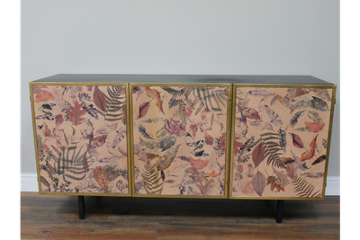 Botanical three-door sideboard featuring leaf and fern artwork, gold trim and slim black legs for elegant storage.