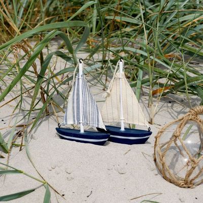 Pair of decorative blue and white sailing boats with fabric sails, perfect for coastal, nautical, and beach-themed décor.