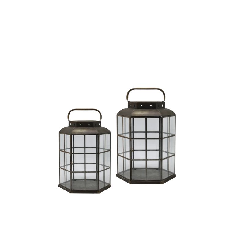 Cove Set of Two Lanterns Set of two hexagonal metal and glass lanterns in antique bronze finish with carry handles, shown in small and large sizes.