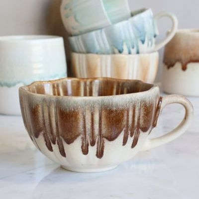 Slow Morning Cup in Toffee Melt, featuring a cream ceramic base, warm caramel-brown dripping glaze, ribbed texture, uneven ri