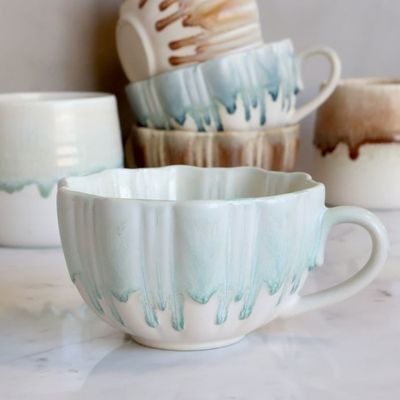 Slow Morning Cup in Seafoam Milk, featuring a cream ceramic base, soft pale-aqua dripping glaze, ribbed texture,.