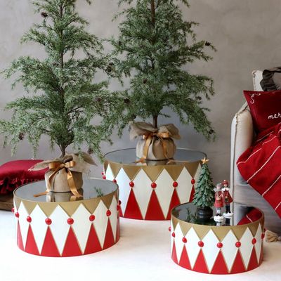 Three large Christmas drum decorations in cherry red, cream and brass, with mirrored tops and harlequin patterns.
