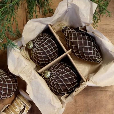 Boxed set of three mocca Christmas baubles in assorted shapes, decorated with a sparkling champagne trellis pattern.