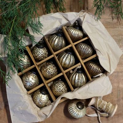 Boxed set of twelve burnished champagne Christmas baubles with four embossed designs and rustic hanging loops.