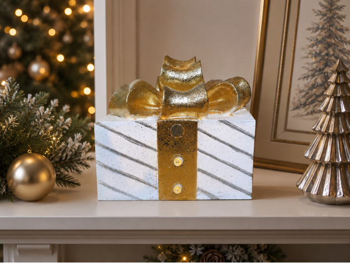 White light-up Christmas present with diagonal silver stripes, a gold ribbon and an oversized glittering bow.