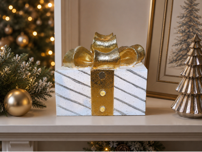 White light-up Christmas present with diagonal silver stripes, a gold ribbon and an oversized glittering bow.