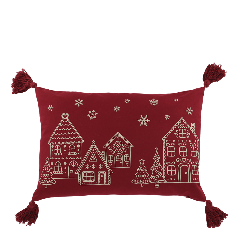 Scarlet rectangular cushion with a cream gingerbread village, Christmas trees, snowflakes and tassels at each corner.
