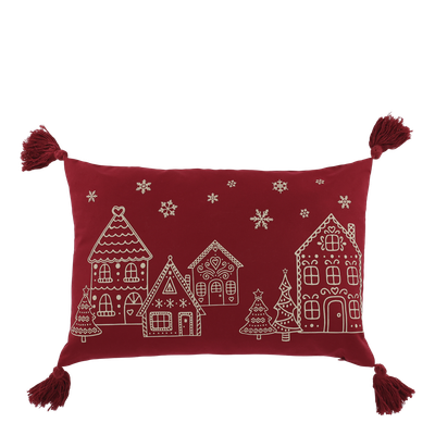 Scarlet rectangular cushion with a cream gingerbread village, Christmas trees, snowflakes and tassels at each corner.
