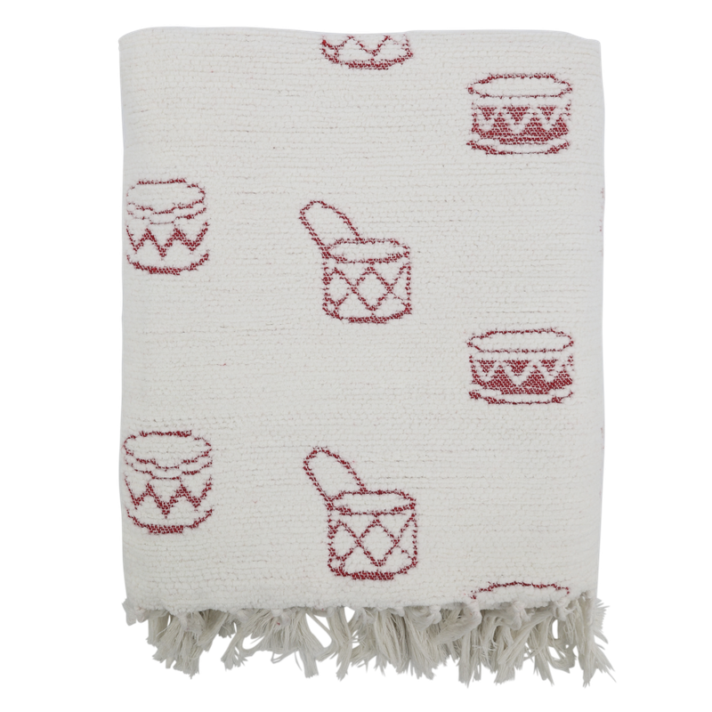 Textured ivory Christmas throw patterned with small red toy drums and finished with a soft fringed edge.
