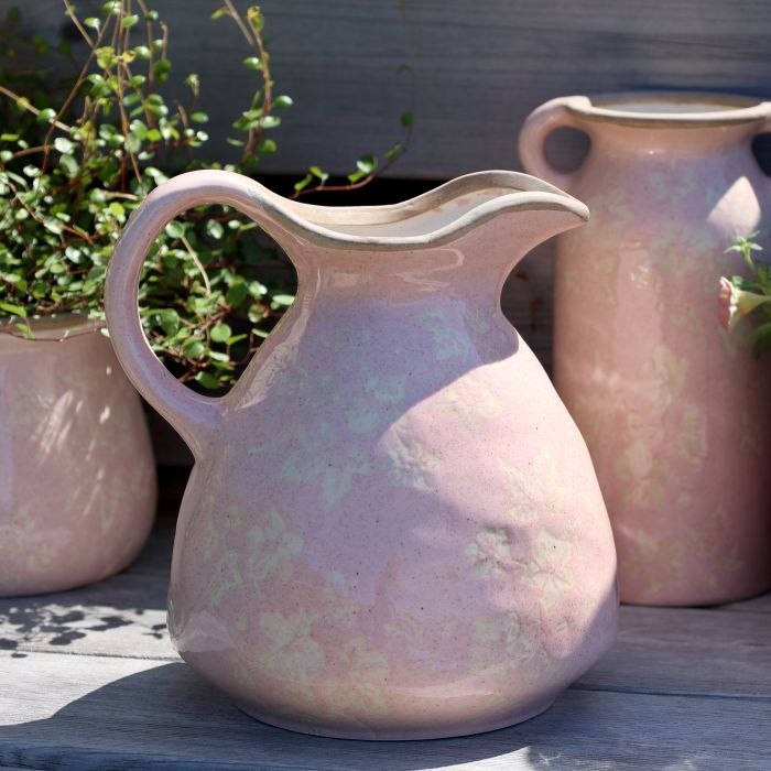 A rounded blush-pink ceramic jug with a curved handle, pouring lip & mottled glaze revealing a faint ivy pattern Jug