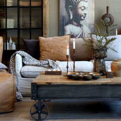 Industrial trolley coffee table with a timber top, dark metal frame and four iron wheels.
