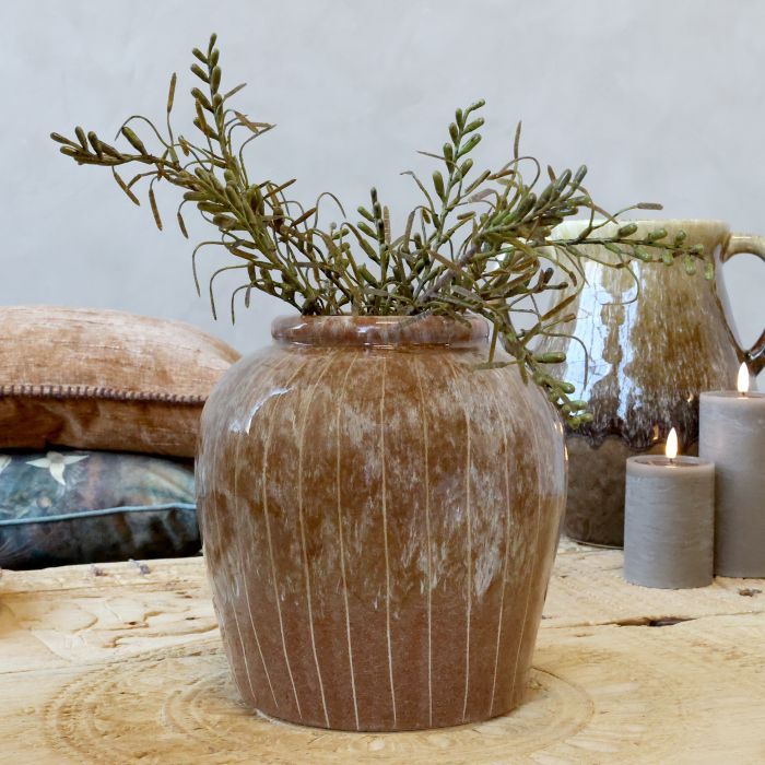 Rounded brown ceramic vase with a short neck, fine vertical grooves and a softly weathered cream glaze.