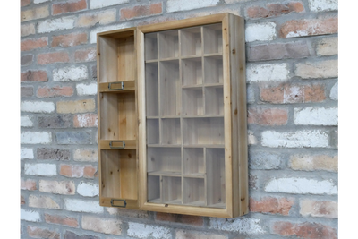 Natural wood display cabinet with a glazed door, varied cubbyholes, open shelves and vintage-style metal label holders.