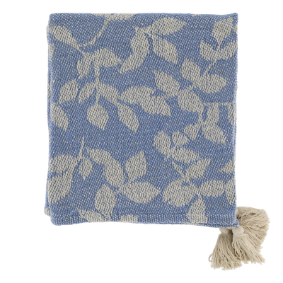 Blue woven throw featuring an ivory leaf and vine pattern, textured finish and decorative cream tassels at the corners.