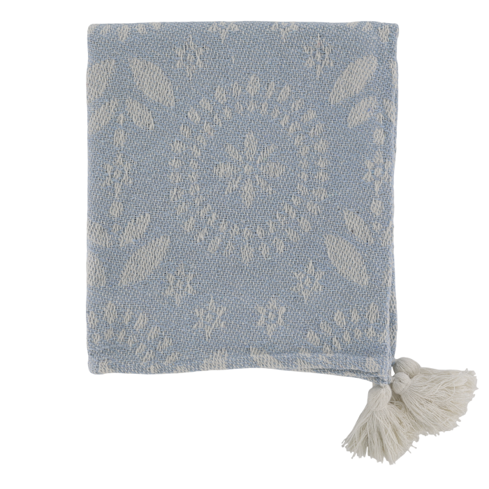 Soft blue woven throw with delicate ivory floral detailing, textured finish and decorative cream tassels at the corners.