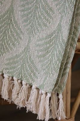 Soft sage green woven throw featuring an elegant ivory herringbone leaf pattern, textured finish and cream fringed edging.