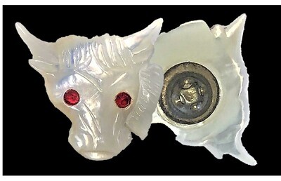 A LARGE CARVED PEARL COW HEAD WITH RED PASTE EYES